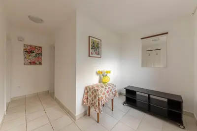 a white room with a table and a mirror at Cozy Garden Flat in Ljubljana