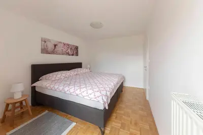 a bedroom with a bed and a table in a room at Cozy Garden Flat in Ljubljana