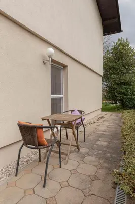 a patio with a table and chairs next to a building at Cozy Garden Flat in Ljubljana