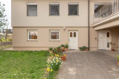 a house with flowers in front of it at Cozy Garden Flat in Ljubljana