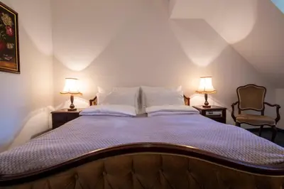 a bedroom with a large bed with two lamps at Herga Wine Estate - Nest above wine cellar - rooms in Ivanjkovci