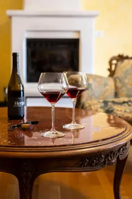 two wine glasses on a table with a bottle of wine at Herga Wine Estate - Nest above wine cellar - rooms in Ivanjkovci