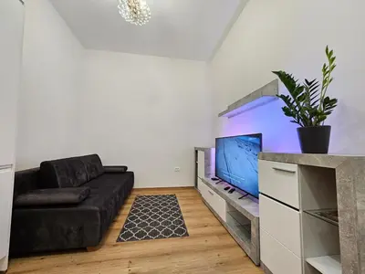 a living room with a couch and a flat screen tv at Studio Apartment Sviti TourAs by Town Hall in Ljubljana