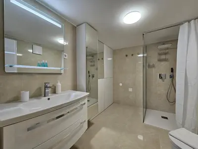 a bathroom with a white sink and a shower at Studio Apartment Sviti TourAs by Town Hall in Ljubljana