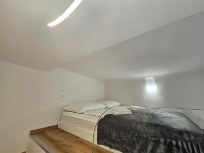 a white bedroom with a bed in a room at Studio Apartment Sviti TourAs by Town Hall in Ljubljana