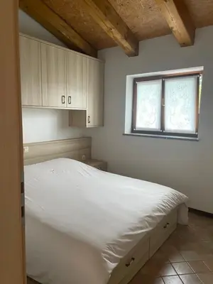 a bedroom with a white bed and a window at Zarova Apartment with wine tasting experience in Kojsko