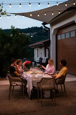 a group of people sitting around a dinner table at Zarova Apartment with wine tasting experience in Kojsko