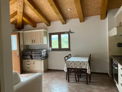 a kitchen with a table and chairs in a room at Zarova Apartment with wine tasting experience in Kojsko