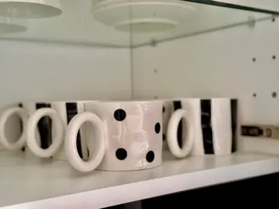 a row of white coffee cups sitting on a counter at Nur Apartment in Bled