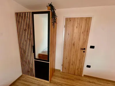 a room with a mirror and a wooden door at Nur Apartment in Bled