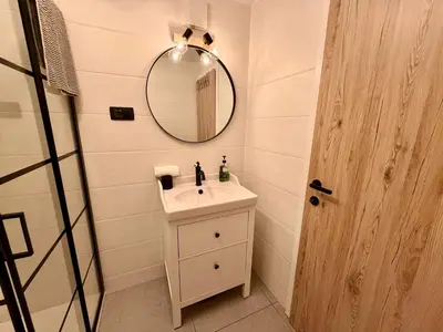 a bathroom with a sink and a mirror at Nur Apartment in Bled