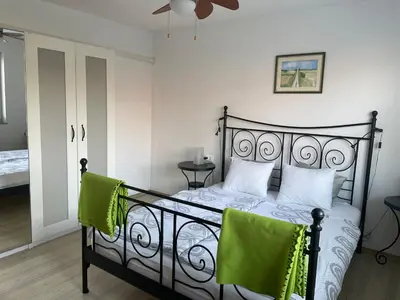 a bedroom with a black bed with two green chairs at Apartments Rose in winter in Bled