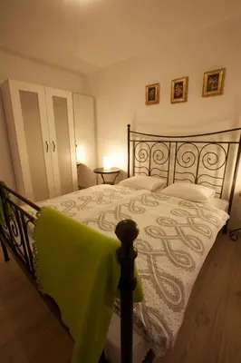 a bedroom with a bed with a green blanket on it at Apartments Rose in winter in Bled