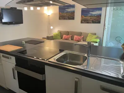 a kitchen with a sink and a couch at Apartments Rose in winter in Bled