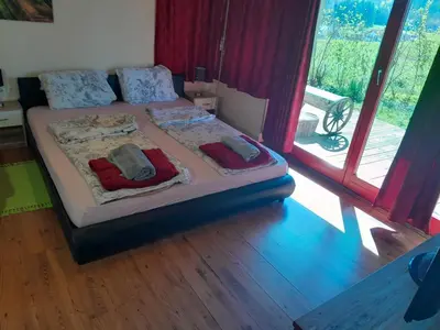a bedroom with a bed with two pillows on it at Tree house Ramona & Fairytale wooden house by Ljubljana in Grosuplje