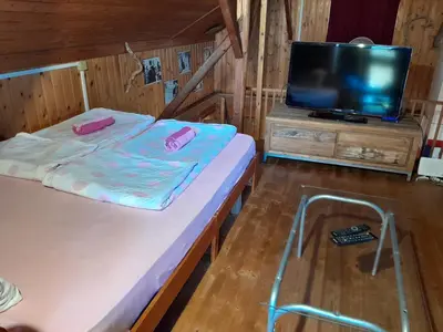 a small room with two beds and a tv at Tree house Ramona & Fairytale wooden house by Ljubljana in Grosuplje