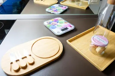 a table with a wooden cutting board with a cell phone at Cute Tiny Flat in Ljubljana
