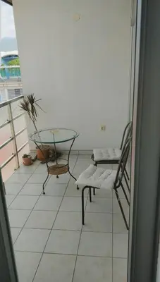 a balcony with a glass table and a chair at Bright&Spaceus Apartment with View in Nova Gorica