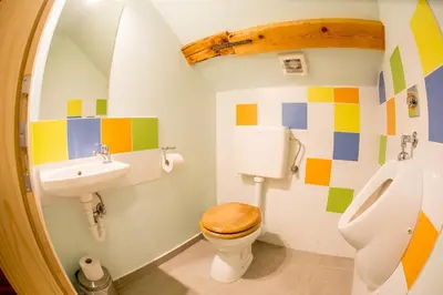 a colorful bathroom with a toilet and a sink at Guest House Kraljev Hrib in Kamniška Bistrica