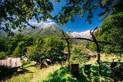 a mountain in the distance with trees and chairs at Guest House Kraljev Hrib in Kamniška Bistrica