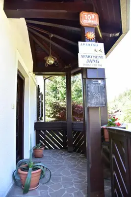 a porch with potted plants and a sign on a building at Apartment JANG in Tolmin