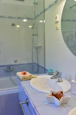a bathroom with a sink and a shower and a mirror at Apartment JANG in Tolmin