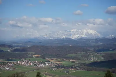 an aerial view of a town with snow covered mountains at Grad Tuštanj in Moravče