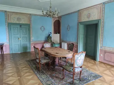 a dining room with a wooden table and chairs at Grad Tuštanj in Moravče