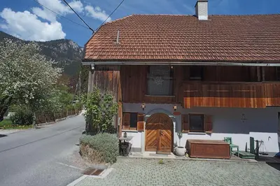 a house with a wooden door on a street at River House Mojstrana in Mojstrana