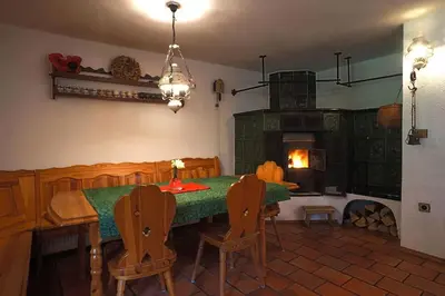 a dining room with a green table and chairs at River House Mojstrana in Mojstrana
