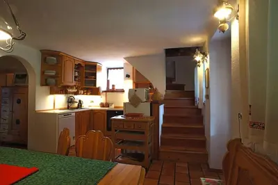 a kitchen with a staircase leading up to a kitchen with a refrigerator at River House Mojstrana in Mojstrana