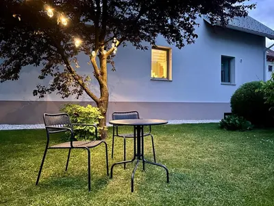 a table and chairs next to a tree in a yard at Apartment Gallus in Bled