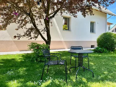 two chairs and a table in a yard with a tree at Apartment Gallus in Bled