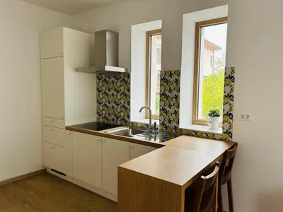 a kitchen with white cabinets and a sink and a window at Apartment Gallus in Bled