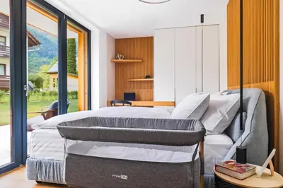 a bedroom with a bed and a large window at Vila Nina Bohinj in Bohinj