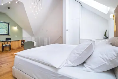 a bedroom with a large white bed and a desk at Vila Nina Bohinj in Bohinj