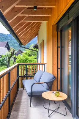 a porch with a blue chair and a table at Vila Nina Bohinj in Bohinj