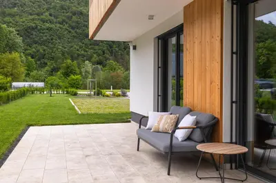a patio with a chair and a view of a yard at Vila Nina Bohinj in Bohinj