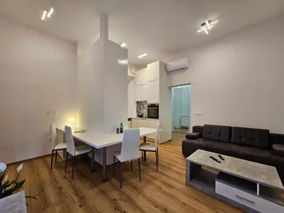a living room with a table and a couch at Relaxed escape in the old town - App Sviti Tour As in Ljubljana