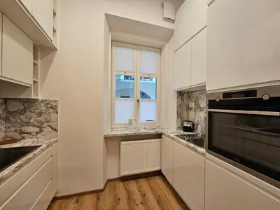 a kitchen with white cabinets and a window at Relaxed escape in the old town - App Sviti Tour As in Ljubljana