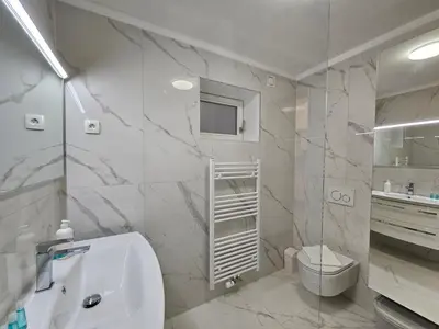 a white bathroom with a toilet and a sink at Relaxed escape in the old town - App Sviti Tour As in Ljubljana