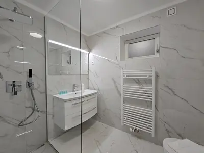 a white bathroom with a shower and a sink at Relaxed escape in the old town - App Sviti Tour As in Ljubljana