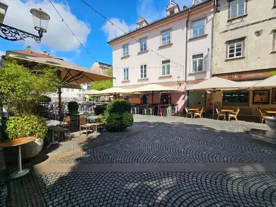 a cobblestone street with tables and chairs and a building at Relaxed escape in the old town - App Sviti Tour As in Ljubljana