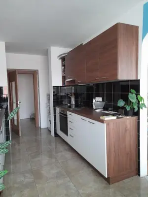 a kitchen with white cabinets and black tiles at Room for women or couples in Ljubljana
