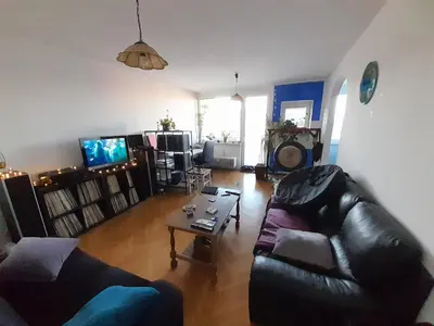a living room with a leather couch and a table at Room for women or couples in Ljubljana