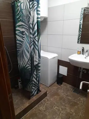 a bathroom with a shower curtain next to a sink at Room for women or couples in Ljubljana