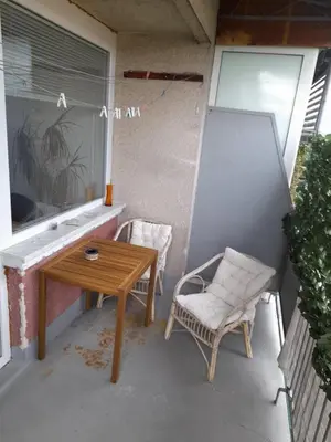 a patio with a table and a chair on a balcony at Room for women or couples in Ljubljana