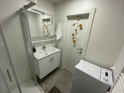 a white bathroom with a sink and a toilet at Apartma Adrian in Kranjska Gora