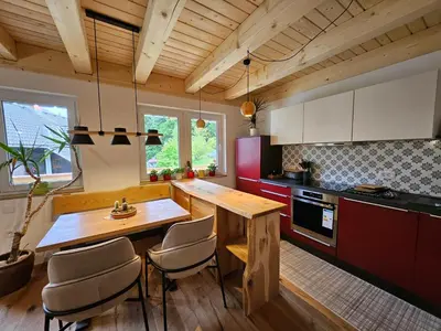 a kitchen with a wooden table and chairs at Apartments Anž'k in Bled