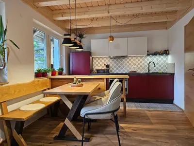 a kitchen with a wooden table and chairs at Apartments Anž'k in Bled